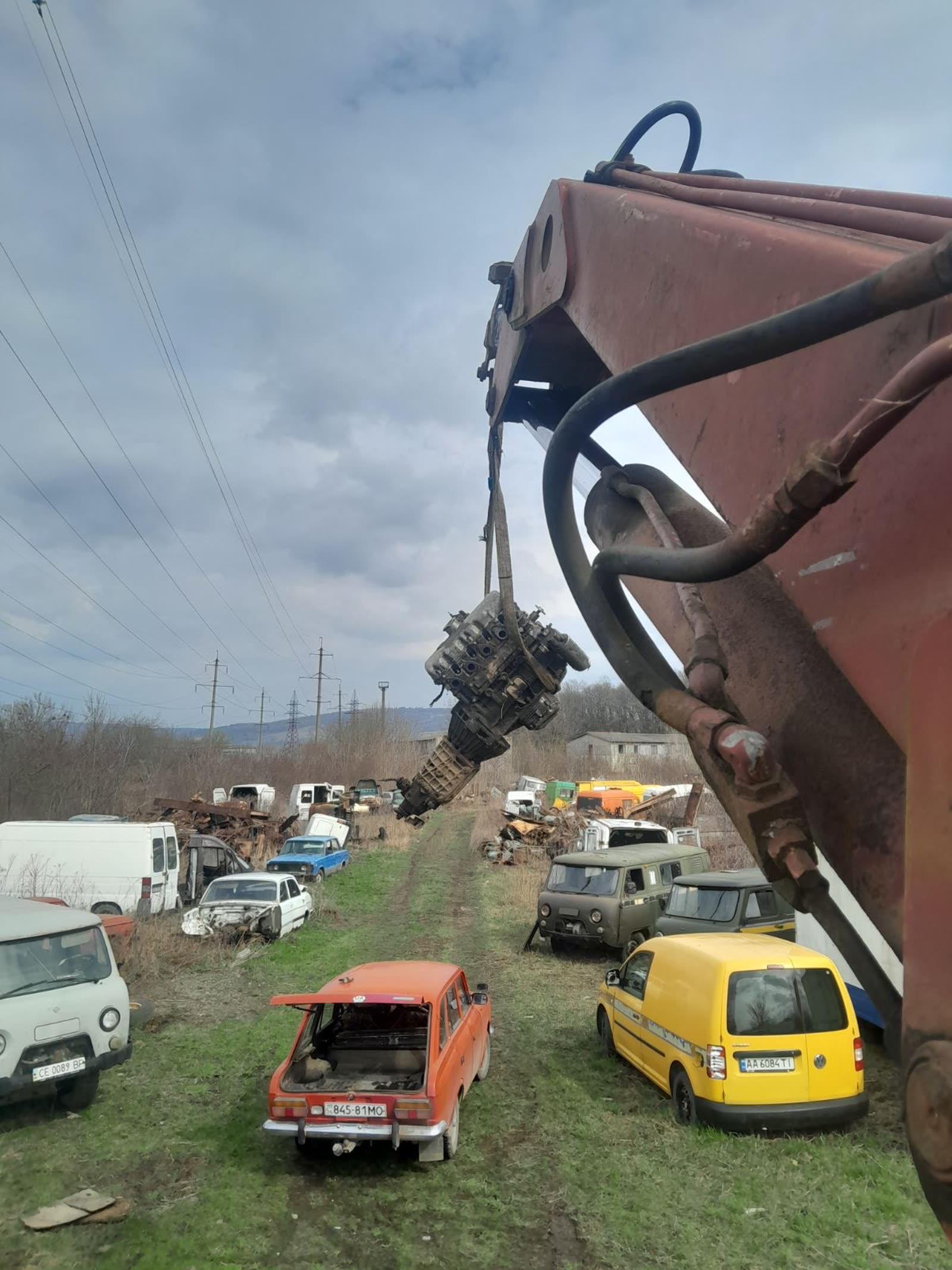 Кран-маніпулятор демонтує важкий вузол на металобазі