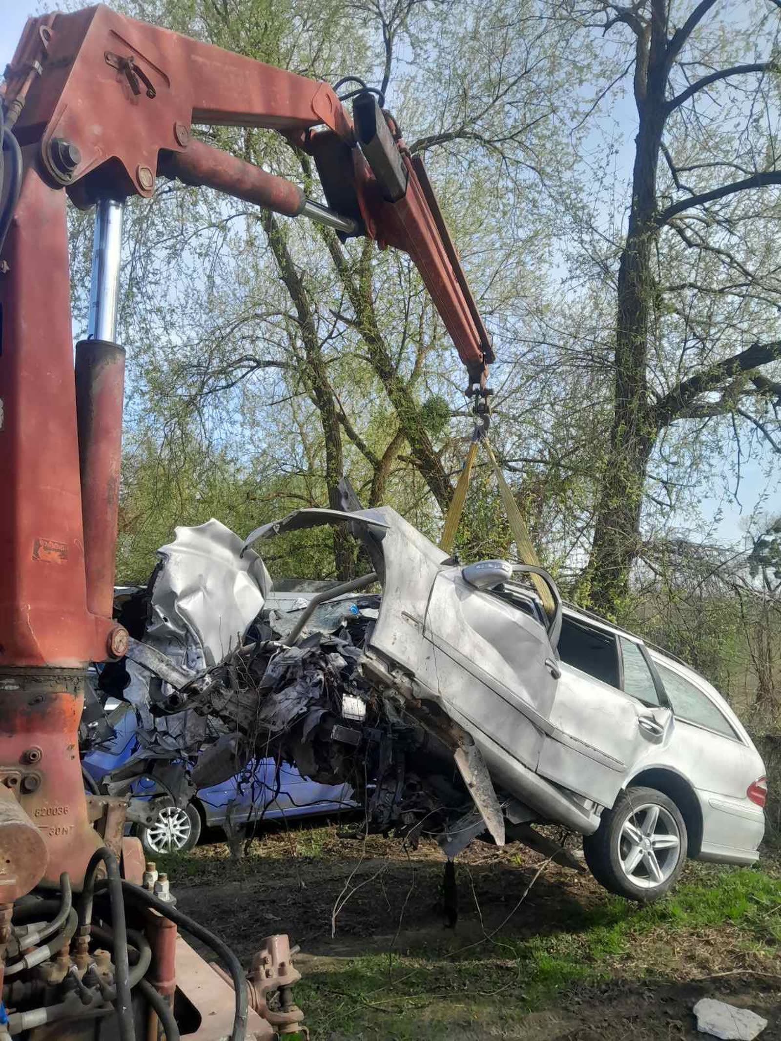 Кран-маніпулятор піднімає розбитий автомобіль
