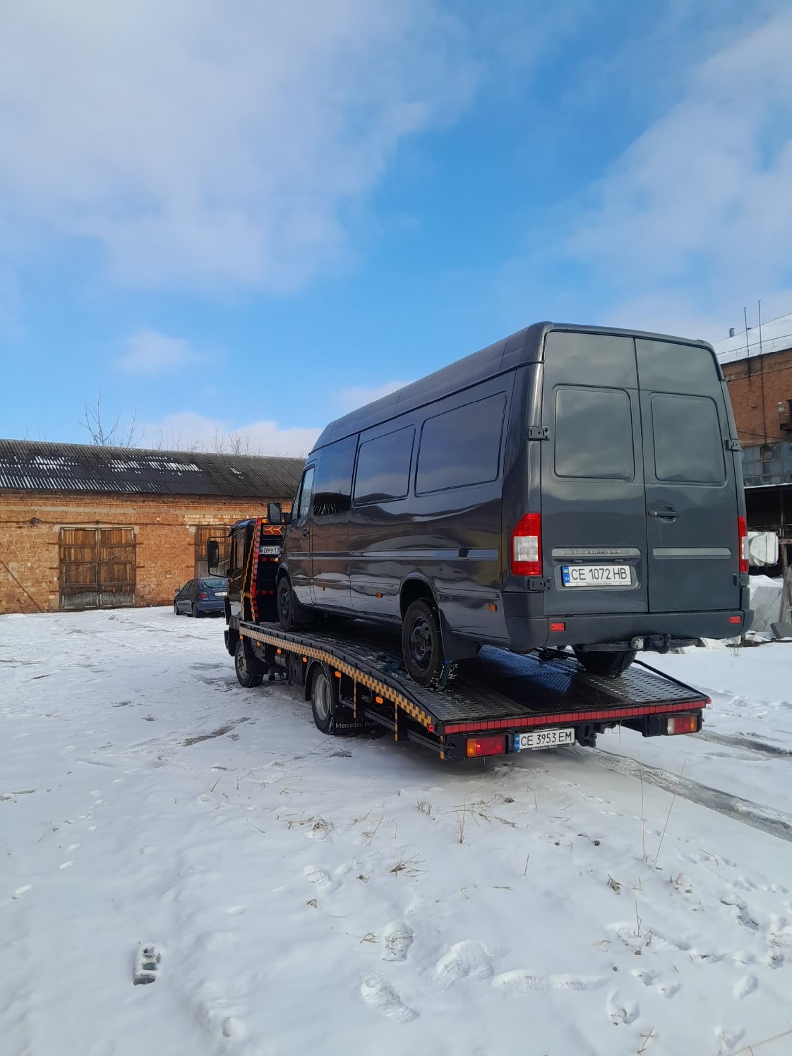 Евакуатор перевозить мікроавтобус Mercedes-Benz на платформі